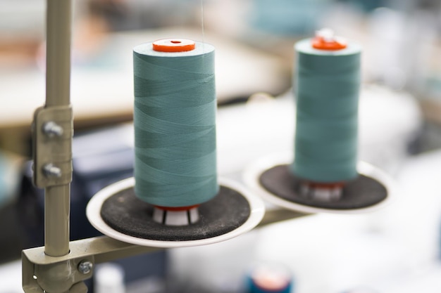 衣服を仕立てるための工業用縫製工場での糸のかせのクローズアップ