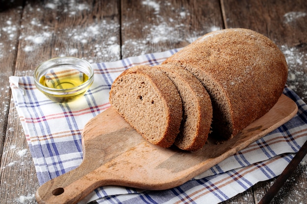 Крупным планом на нарезанный серый буханка хлеба с маслом