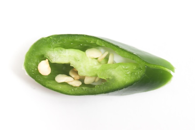 Closeup sliced green hot chili pepper top view isolated on white background clipping path