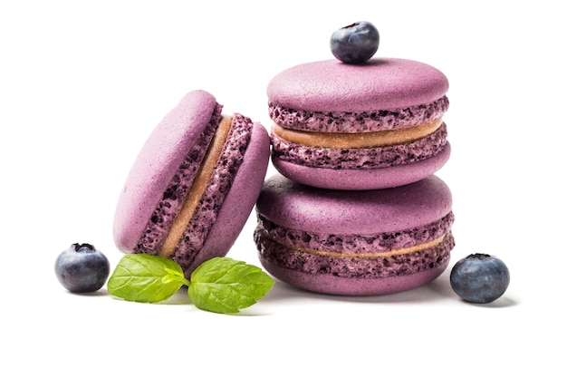 Closeup of small macaroons with blackberries on white background