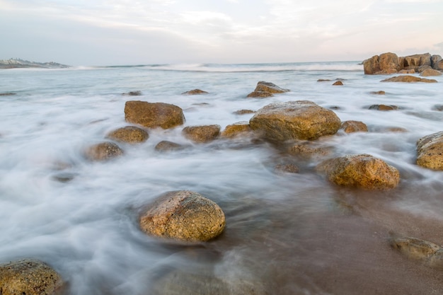 Closeup of the small rocks on the shore against the horizon