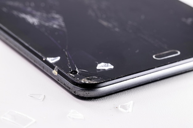 Closeup of smartphone model mobile device with broken screen or\
protective film white background copyspace