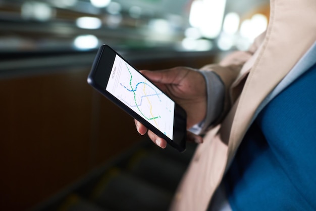 Closeup of smartphone with metro route map on screen in hand of young African American woman