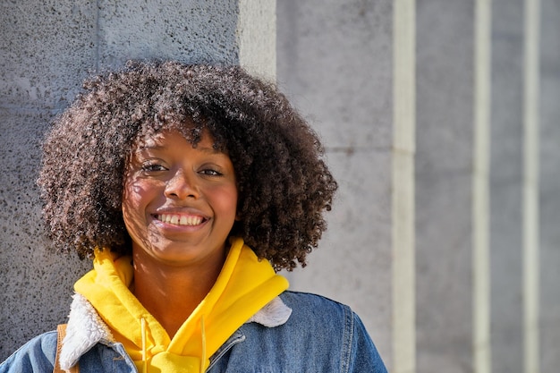 Closeup of smiling young black girl with afro hair standing looking at the camera