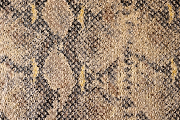 Closeup of smooth brown and black cotton fabric with stylish snake print texture background