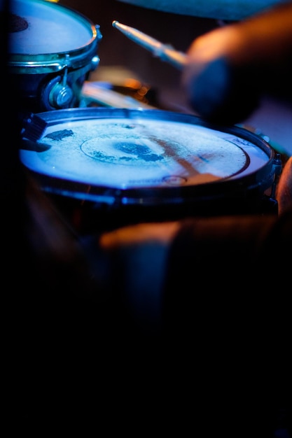 Photo closeup of a snare drum being played by a drummer in concert vertical copy space