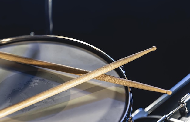 Photo closeup snare drum and drumsticks on a dark background