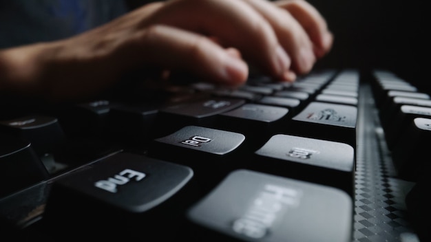 Closeup soft focus finger typing on keyboard. man hand using laptop computer in office. programming and online marketing business concept.