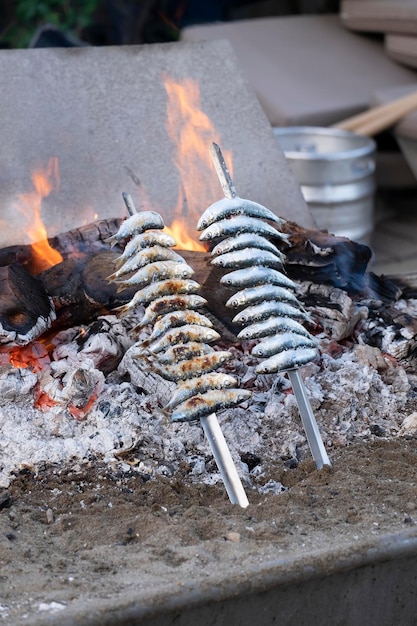 Closeup of some espetos beeing cooked in a wood fire