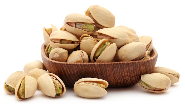 Closeup of some roasted pistachio in bowl over white background