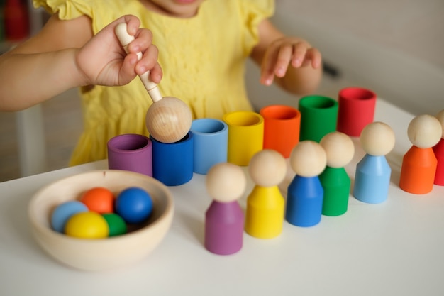 Closeup of a sorter toy with balls cups and a wooden spoon