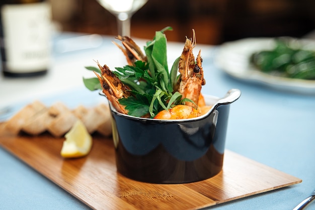 Photo closeup on spanish dish gambas pil-pil shrimps on the restaurant table