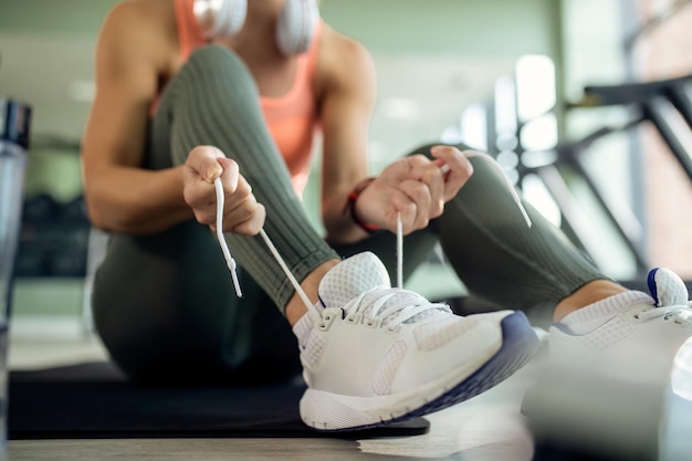 Closeup of sportswoman tying shoelace in a gym