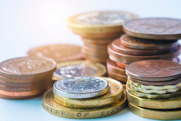 Closeup of stacking of pound sterling  coins on exchange rate of newspaper