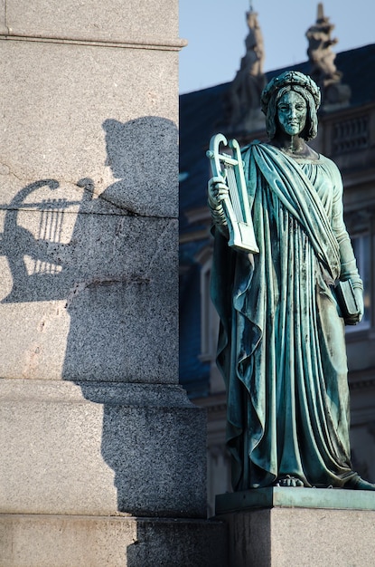 Photo closeup of a statue of a female holding lyre and a book at the jubilee column in stuttgart germany