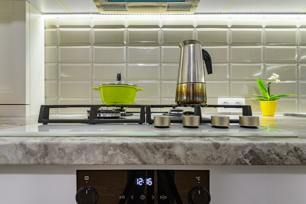 Closeup to stove on white cozy and comfy contemporary classic kitchen interior with wooden furniture, front view