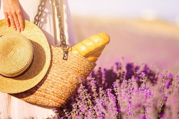 Closeup straw bag and hat in lavender field