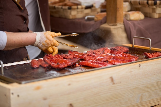 Closeup of a street stall where sausages are cooked