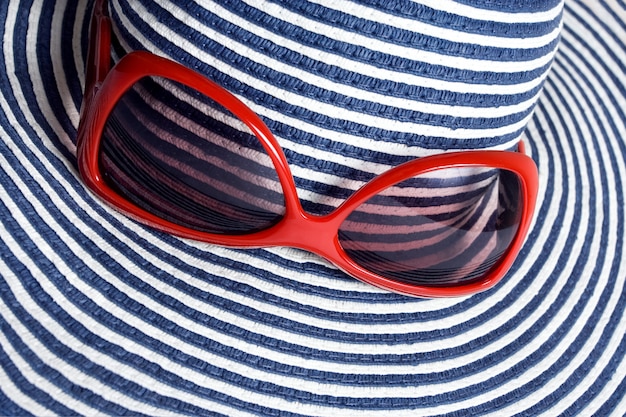 Photo closeup of striped hat and red sunglasses