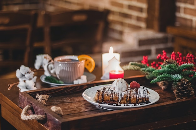 Photo closeup of a strudel with a strawberry on a christmas plate near bamboo branch.