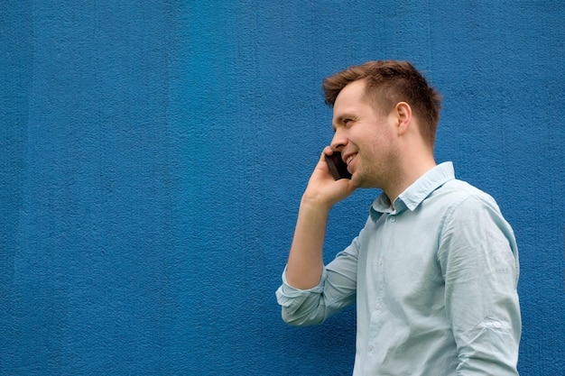 Closeup of a successful young business man talking on cell phone at modern office