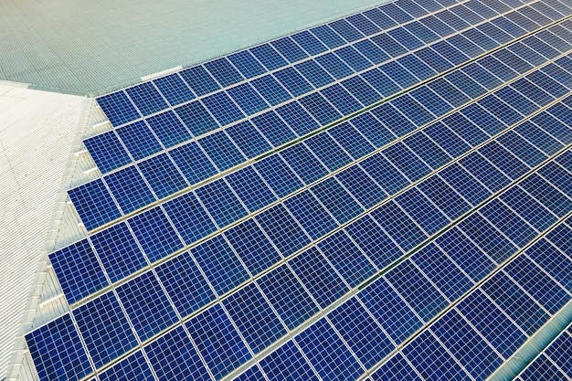Closeup of surface of blue photovoltaic solar panels mounted on building roof for producing clean ecological electricity. Production of renewable energy concept.