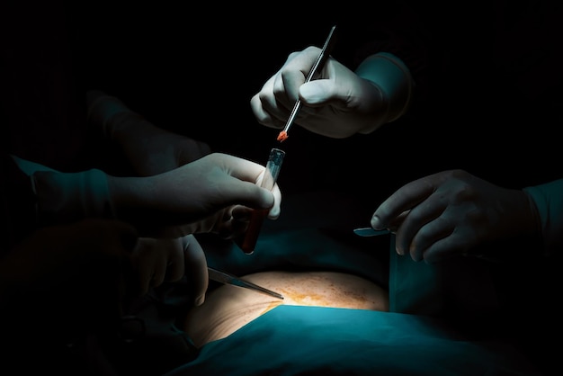 Foto team chirurgico di primo piano che esegue un intervento chirurgico al paziente in sala operatoria sterile