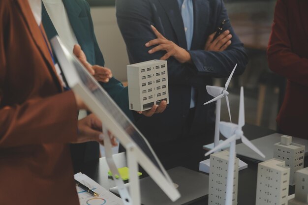 Photo closeup at tablet engineers pointing at tablet with their hands to jointly design the use of renewable energy with wind and solar energy concept of using renewable energy