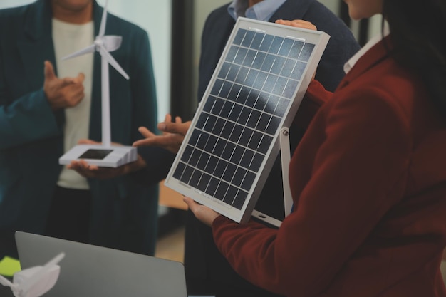 Closeup at tablet Engineers pointing at tablet with their hands To jointly design the use of renewable energy with wind and solar energy Concept of using renewable energy