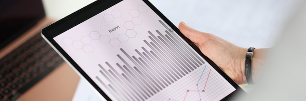 Photo closeup of tablet with graphs in hands of woman. profit growth concept