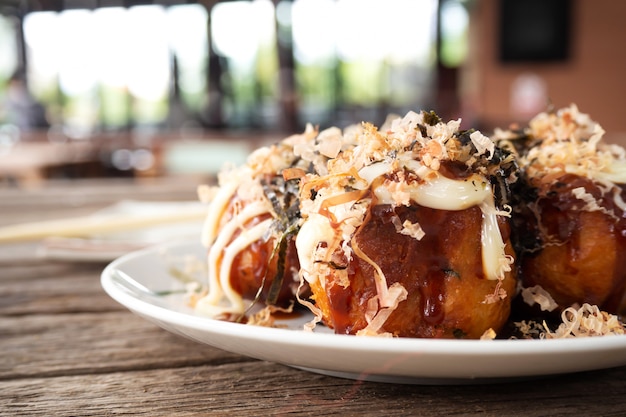 Foto takoyaki del primo piano. calamari con griglia di gnocchi di verdure e farina. antipasto preferito cibo giapponese.