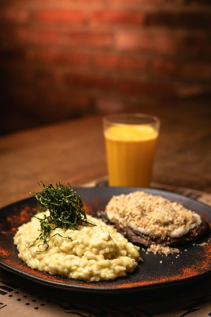 Closeup of tasty meal on a wooden cutting board with brick wall on background