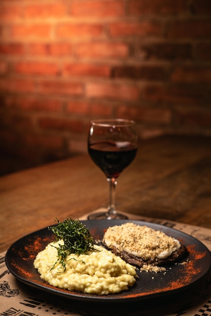 Closeup of tasty meal on a wooden cutting board with brick wall on background