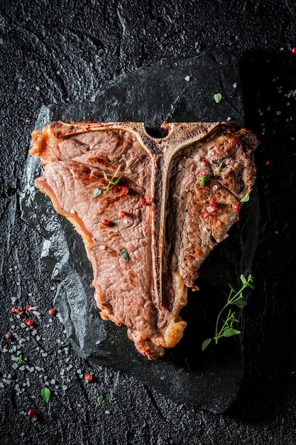 Closeup of tbone steak with herbs and pepper