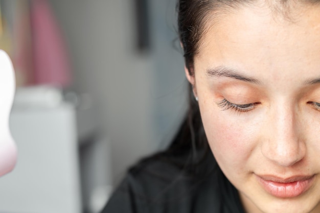 Closeup of a teenage girl's face without makeup looking down ready to start applying makeup