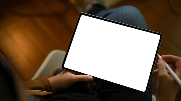 Primo piano una ragazza adolescente che utilizza il touchpad digitale della tavoletta nel suo accogliente soggiorno mockup di tablet
