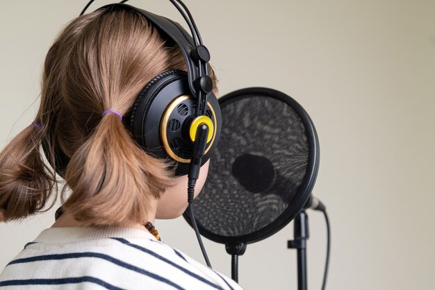 Foto primo piano dell'adolescente che registra musica nello studio domestico.