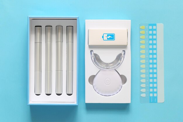 Photo closeup of teeth whitening kit on blue background