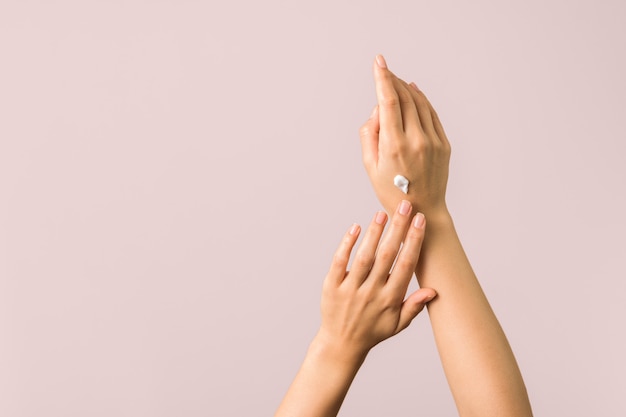 Closeup of tender hands of a young woman with moisturizer