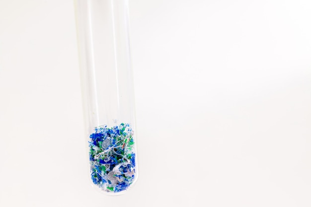 Closeup of test tube with traces of plastic and micro plastic taken from the ocean polymer particles pollutant from the seas environmental problem