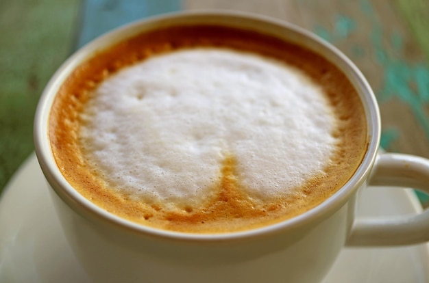 Primo piano la consistenza del caffè cappuccino con schiuma di latte su tavola di legno rustica