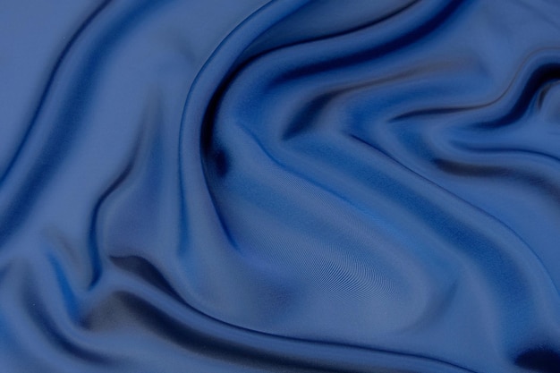 Closeup texture of natural blue fabric or cloth in same color Fabric texture of natural cotton silk or wool or linen textile material Blue canvas background