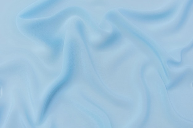 closeup texture of natural blue fabric or cloth in same color fabric texture of natural cotton silk or wool or linen textile material blue canvas background