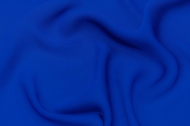 Closeup texture of natural blue fabric or cloth in same color Fabric texture of natural cotton silk or wool or linen textile material Blue canvas background