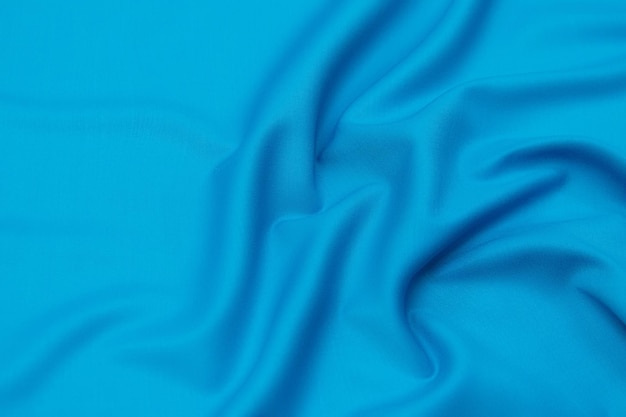 Closeup texture of natural blue fabric or cloth in same color Fabric texture of natural cotton silk or wool or linen textile material Blue canvas background