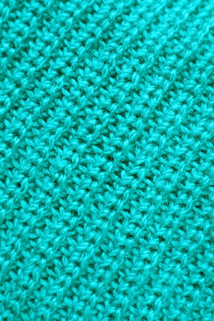 Крупным планом текстура бирюзово-синей трикотажной шерстяной ткани в диагональных узорах
