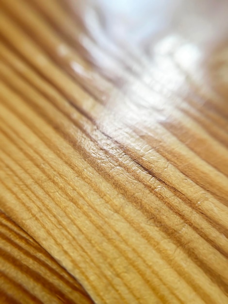 closeup texture of a wooden table with reflections of light on it