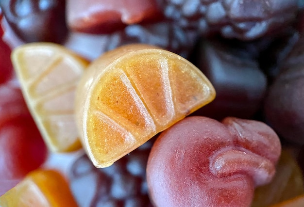 Closeup texture of yellow red and pink multivitamin tablets in form of fruits Healthy lifestyle concept