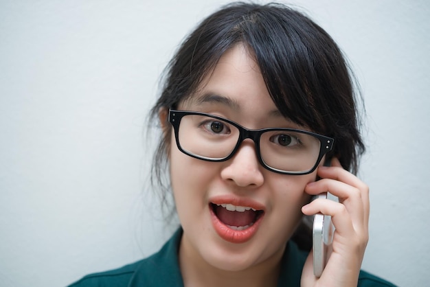 Closeup thaise vrouw gebruikt smartphone op witte muur Aziatisch meisje belt telefoon voor werk Praten op mobiele telefoon