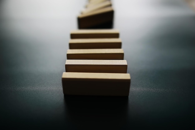 Closeup thick domino wood block in a row stop the falling be stable in crisis business solution concept